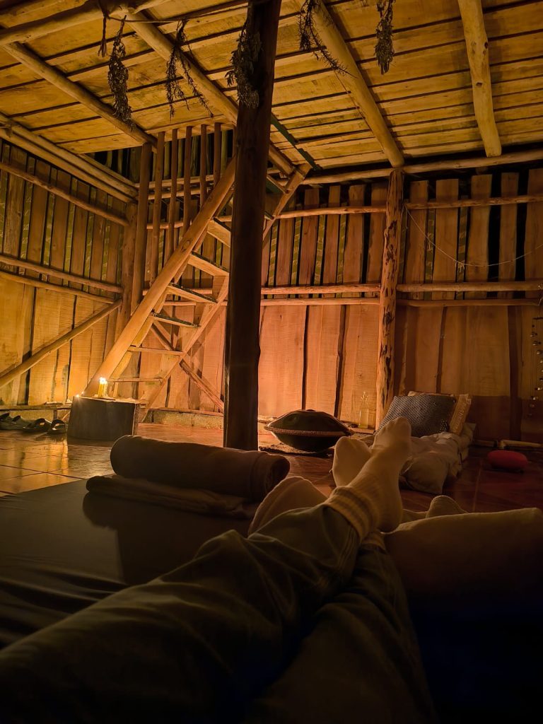 Facilitator providing gentle support during a private psilocybin therapy session in a calm, professional setting