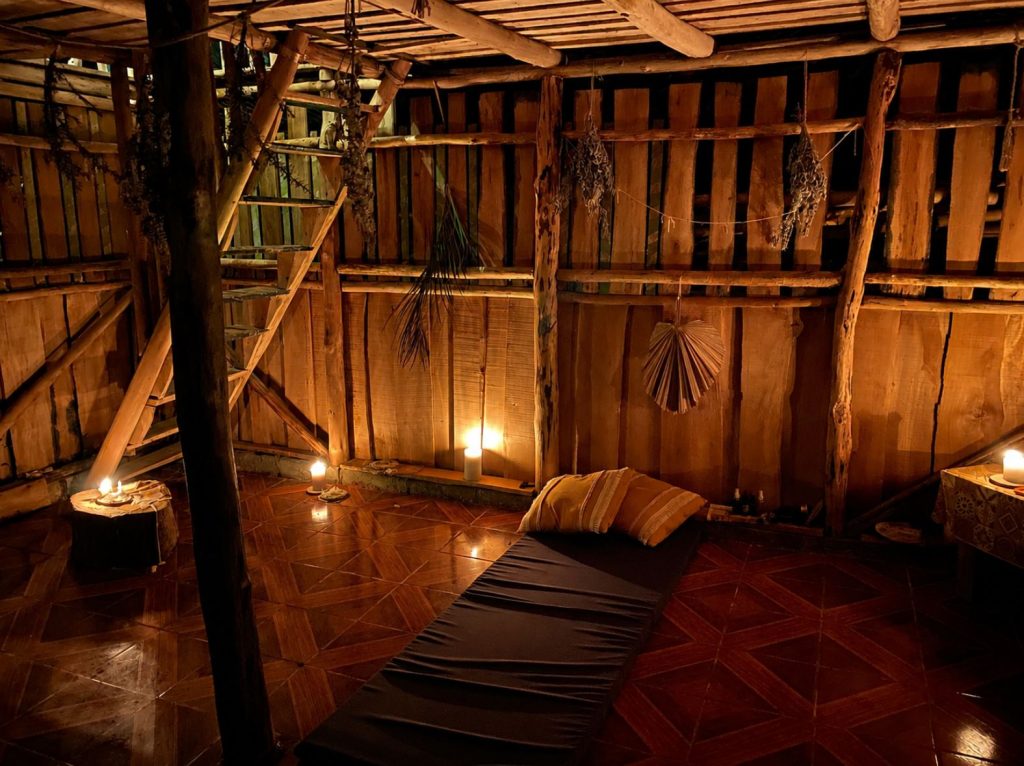Candlelit ceremony space inside a rustic wooden retreat cabin