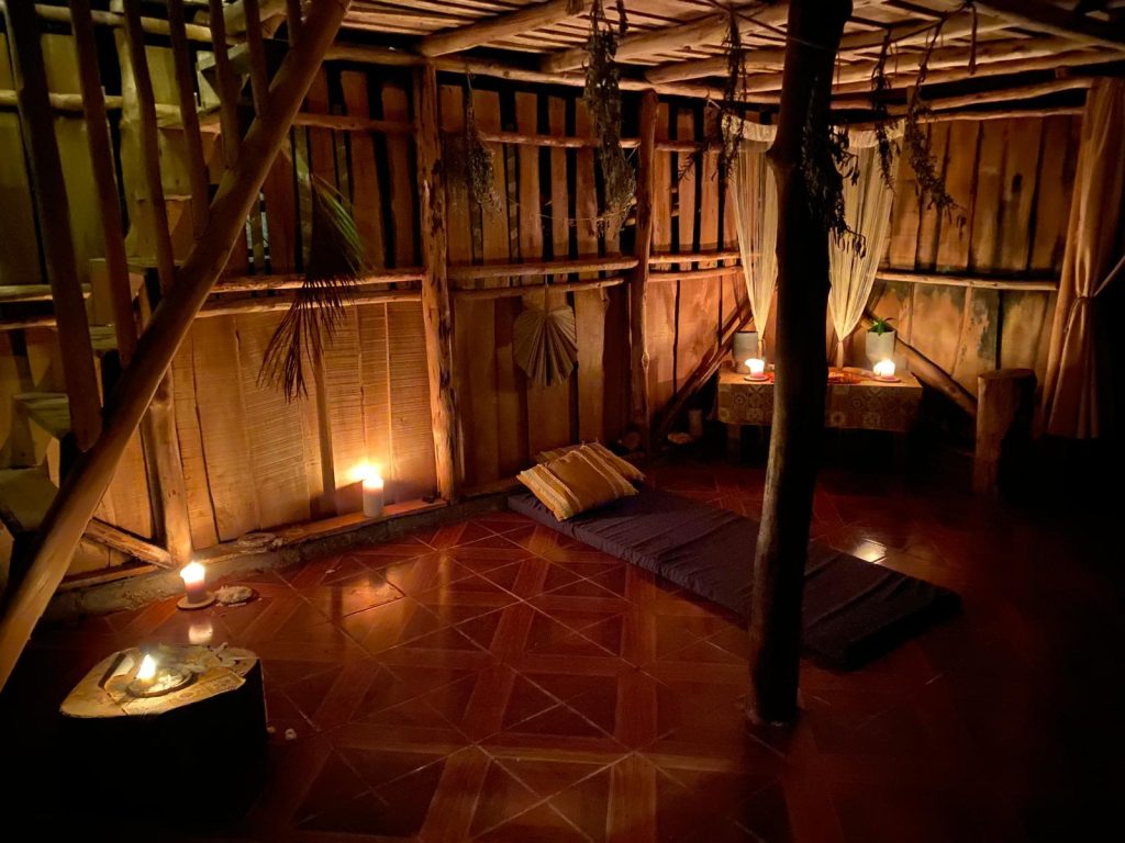 Private candlelit ceremony space inside a rustic wooden retreat cabin